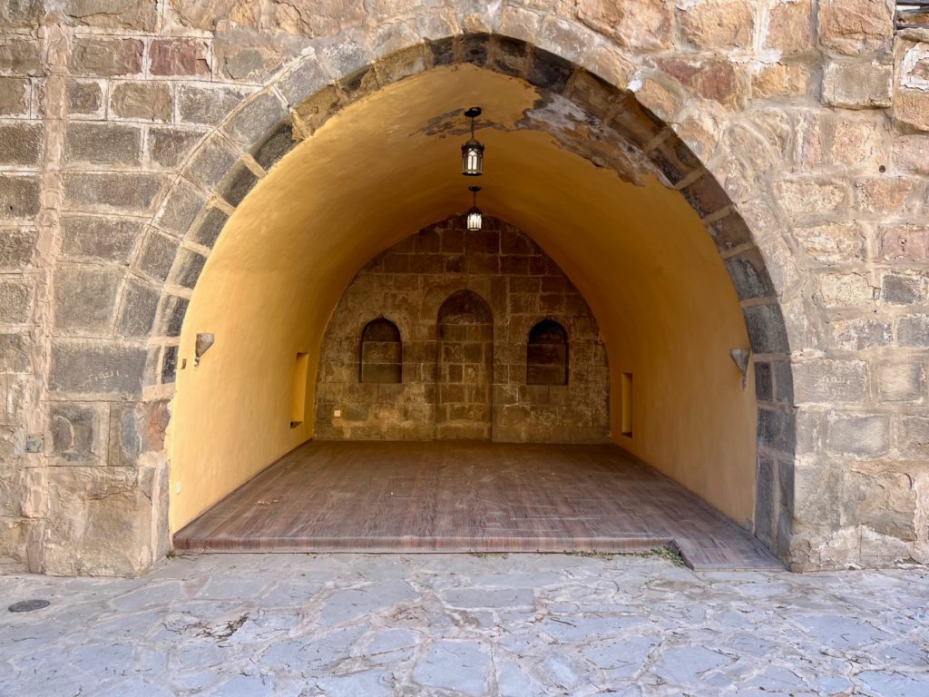 carved out niche area of a stone wall with a wooden floor