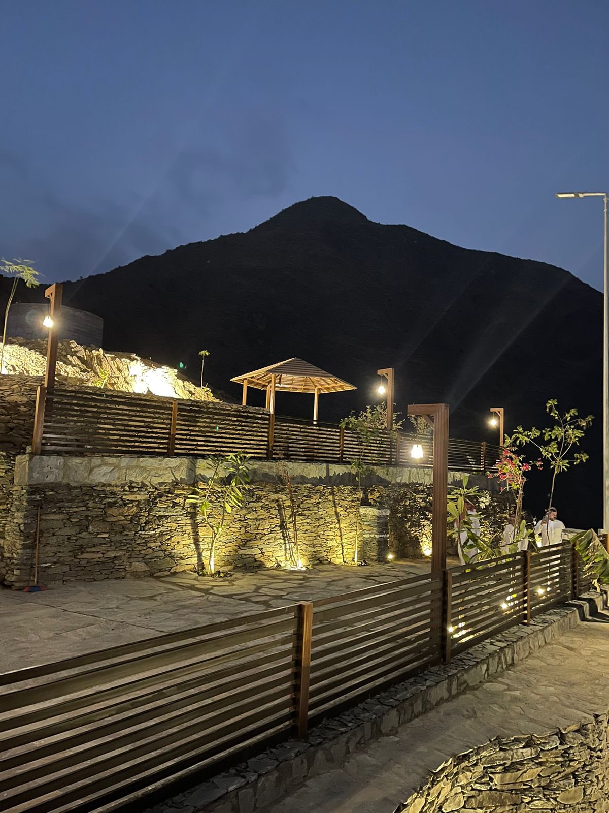 stone walls lit at dusk with a mountain's shadow in the background