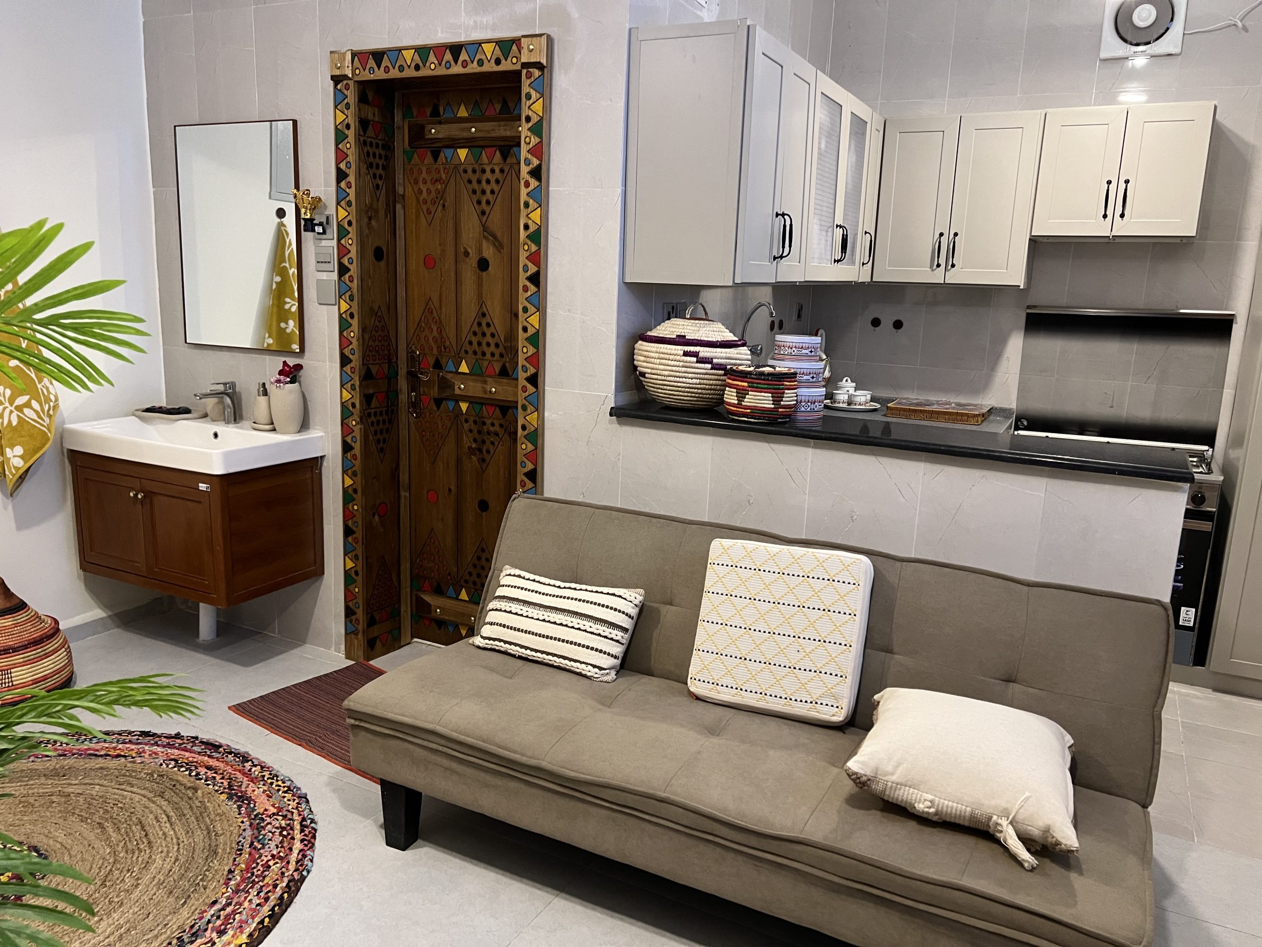 inside of a new home with couch, sink, kitchen, and a decorated door