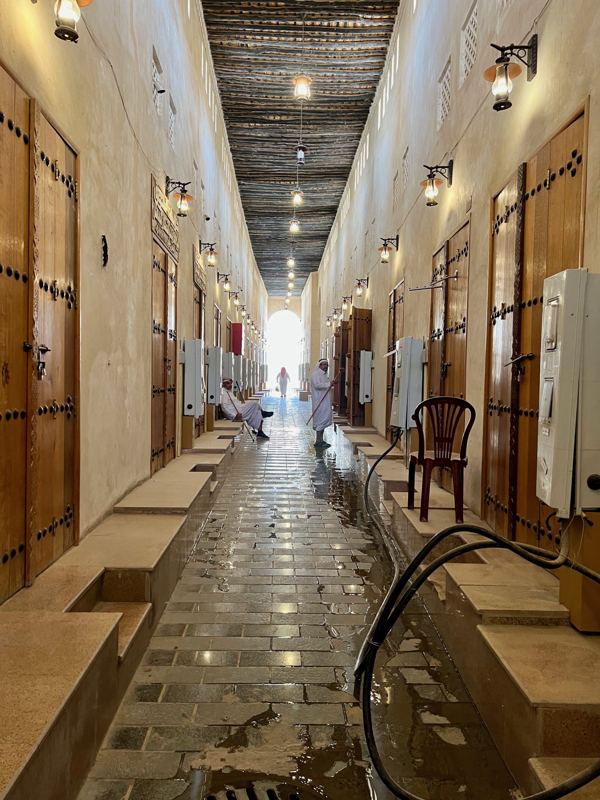 an empty corridor of shops with their doors closed