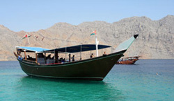 A traditional Arab sailing dhow, fashioned from wood and crafted by hand in the manner of Omani shipwrights and mariners of yesteryear, plies the sea in and out of the Hormuz Strait, the world's most strategically vital waterway.