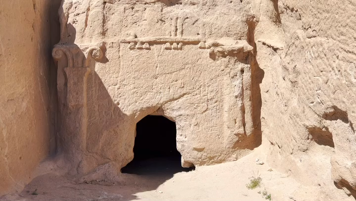 styled carvings in a rock face with a hole to enter inside to a carved out room