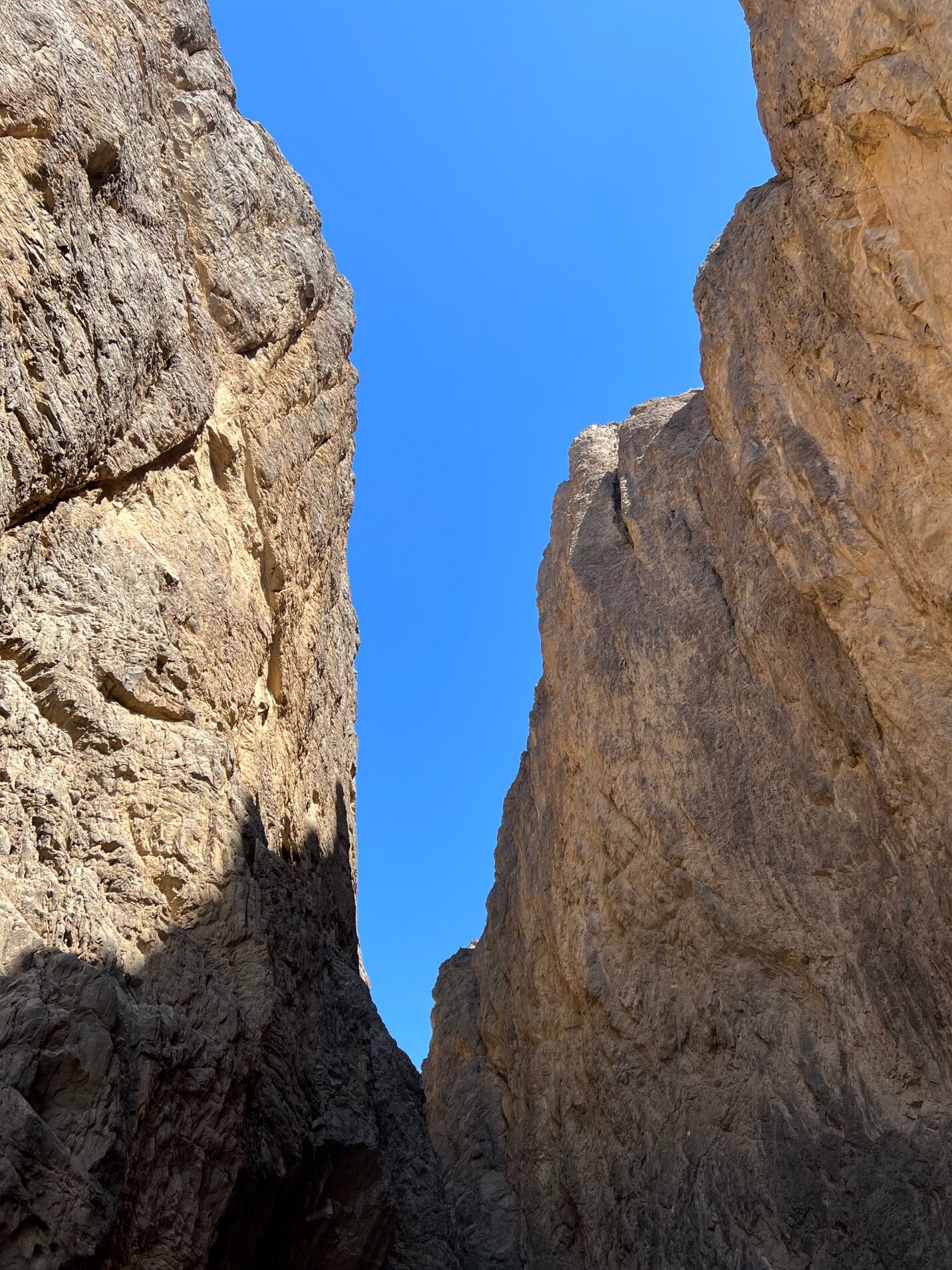 two rock cliffs open to a blue dky